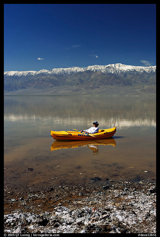 Salt formations, kayaker, and Panamint range. Death Valley National Park, California, USA.