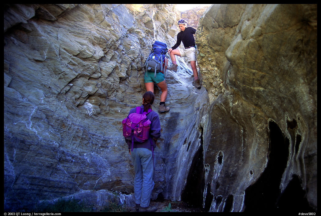 Hikers climbing in a narrow side canyon. Death Valley National Park, California, USA.
