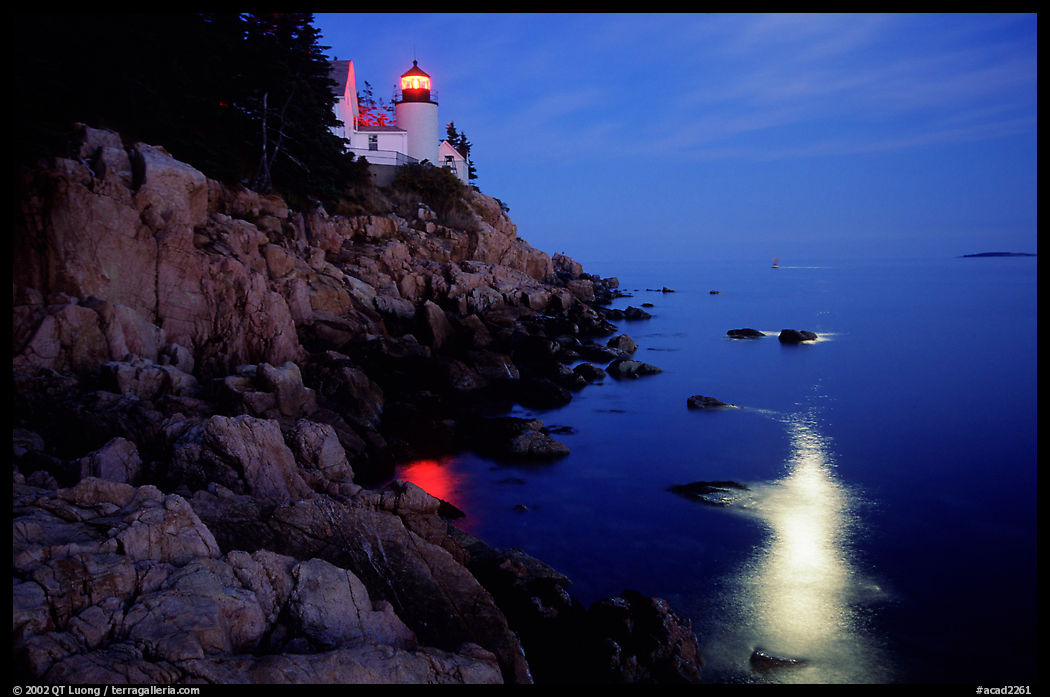 Bass Harbor lighthouse by night with moon reflection in ocean. Acadia National Park