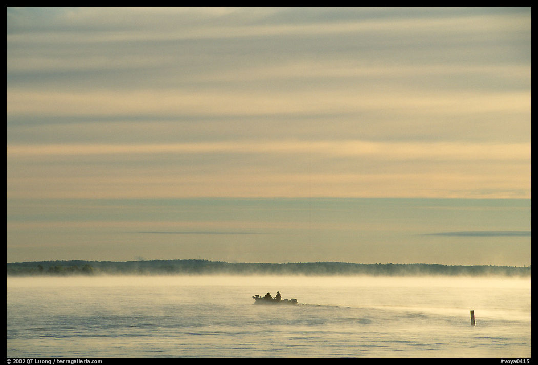Boaters in fog, early morning, Kabetogama lake. Voyageurs National Park, Minnesota, USA.