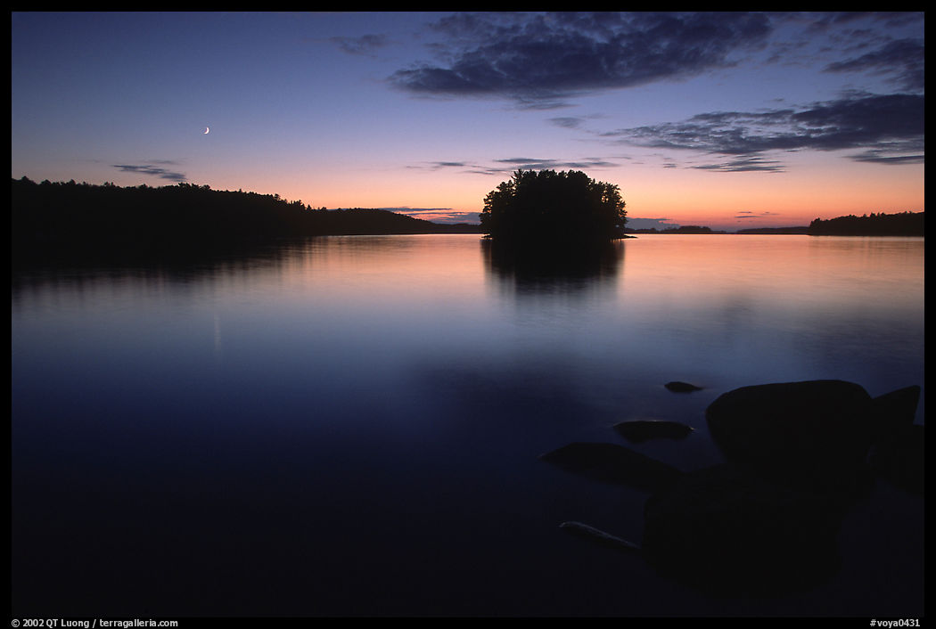 Sunset with moon on island on Kabetogama Lake near Ash river. Voyageurs National Park, Minnesota, USA.