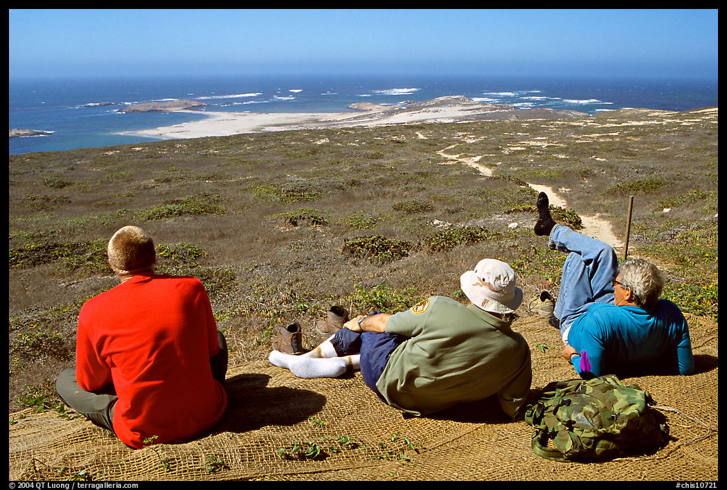Hikers observing Point Bennett from a distance, San Miguel Island. Channel Islands National Park, California, USA.