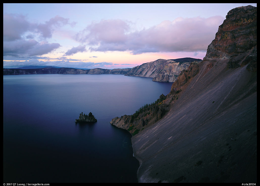 Caldera slopes and Phantom ship at dusk. Crater Lake National Park, Oregon, USA.