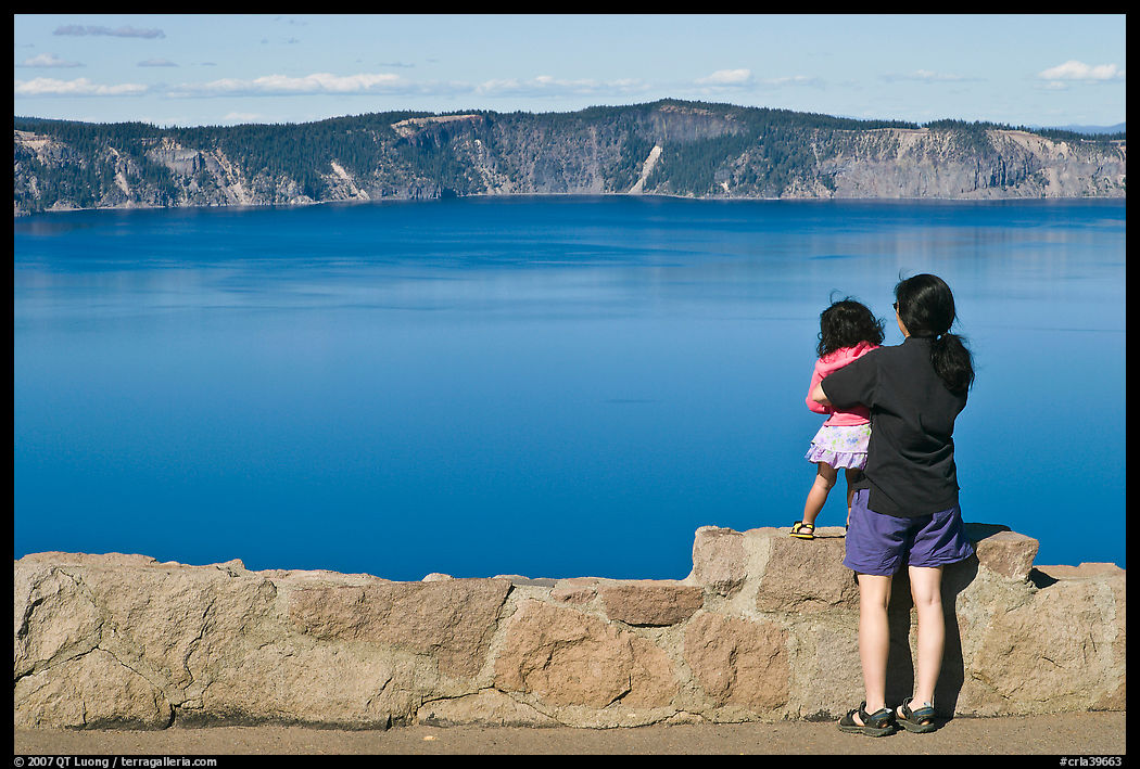Woman and baby looking at Crater Lake. Crater Lake National Park, Oregon, USA.