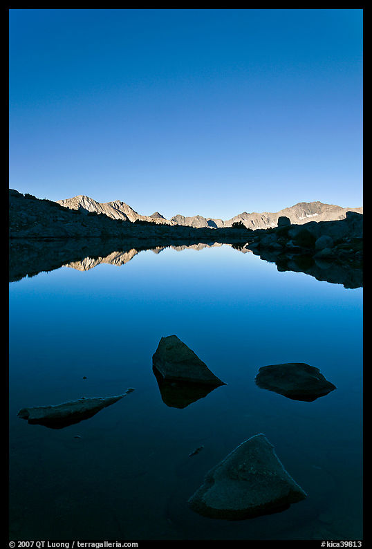 Rocks and calm lake with mountain reflections, early morning, Dusy Basin. Kings Canyon  National Park, California, USA.