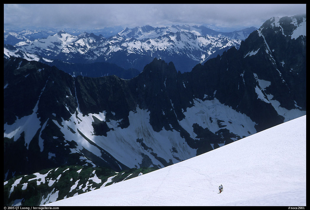 Mountain ridges, and mountaineers on snow field. North Cascades National Park, Washington, USA.