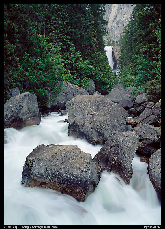 Boulders in frosty Merced River and distant Vernal Fall. Yosemite National Park, California, USA.