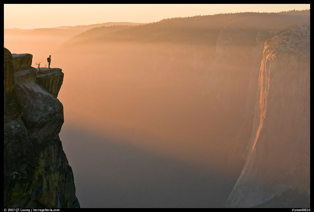 Hiker standing on top of sheer cliff at Taft point. Yosemite National Park, California, USA.