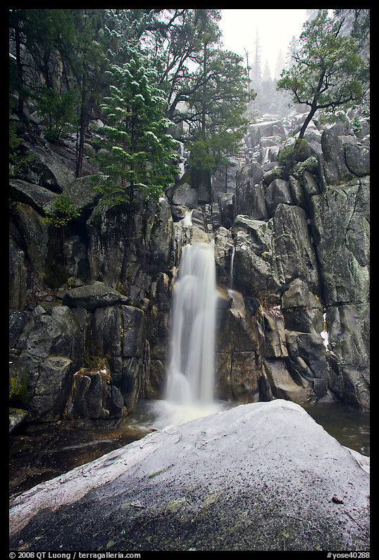 Snow-covered boulder and base of Chilnualna Falls. Yosemite National Park, California, USA.