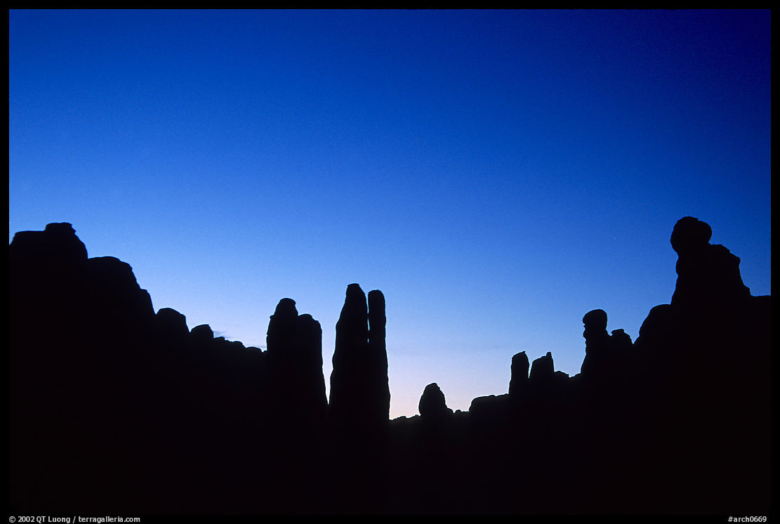 Sandstone pillars in Klondike Bluffs seen as silhouettes at dusk. Arches National Park, Utah, USA.