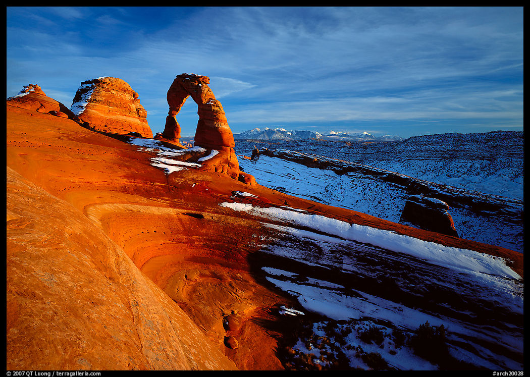 Sandstone bowl, Delicate Arch, and La Sal Mountains with snow, sunset. Arches National Park, Utah, USA.