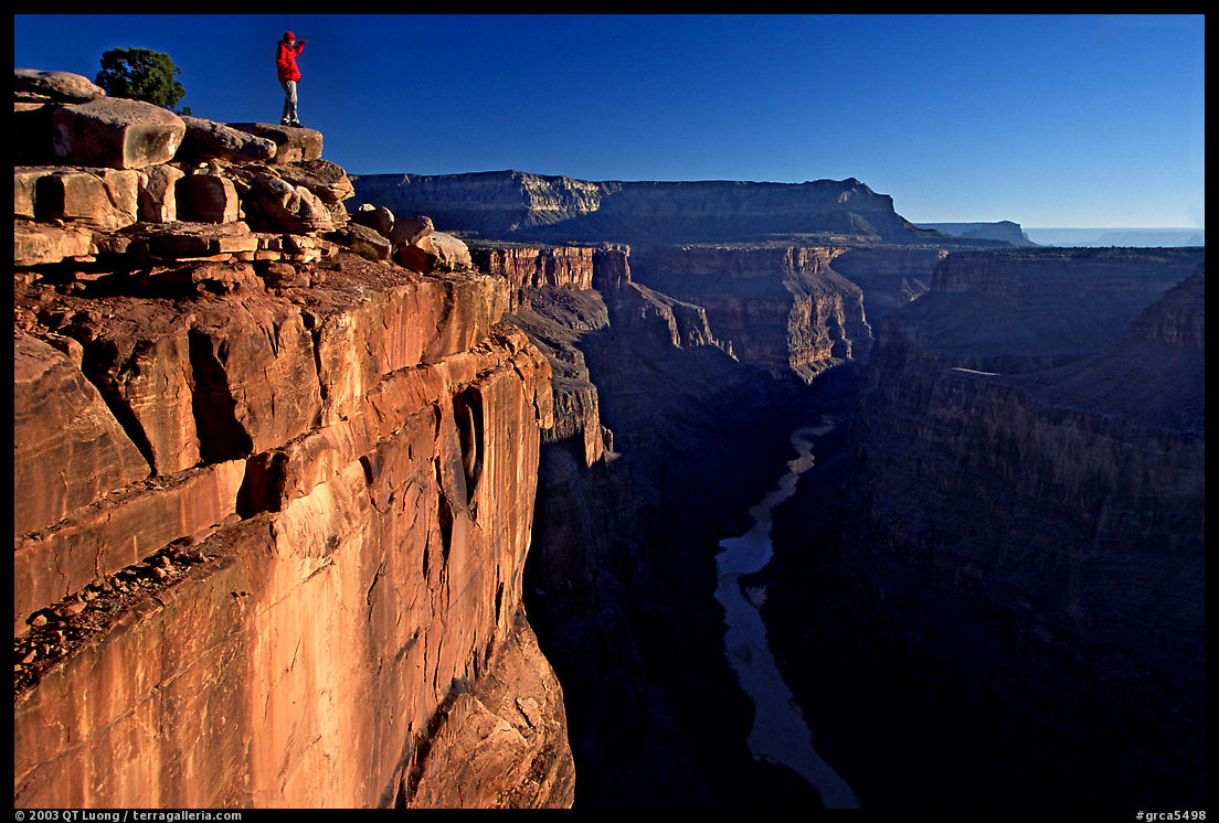 Hiker looking down into  Grand Canyon at Toroweap, early morning. Grand Canyon  National Park, Arizona, USA.
