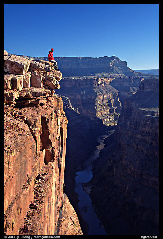 Visitor sitting on  edge of  Grand Canyon, Toroweap. Grand Canyon  National Park, Arizona, USA.
