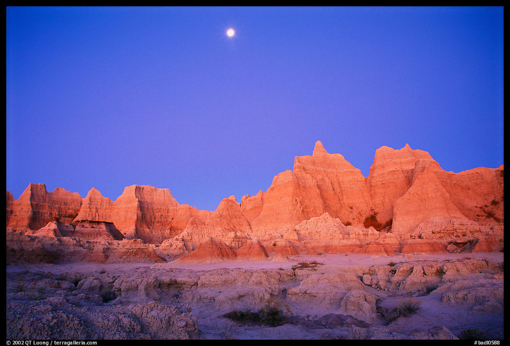 Moon and eroded badlands, Cedar Pass, dawn. Badlands National Park, South Dakota, USA.