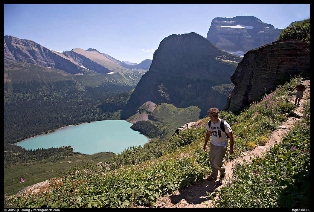 Hikers on trail overlooking Grinnell Lake. Glacier National Park, Montana, USA.