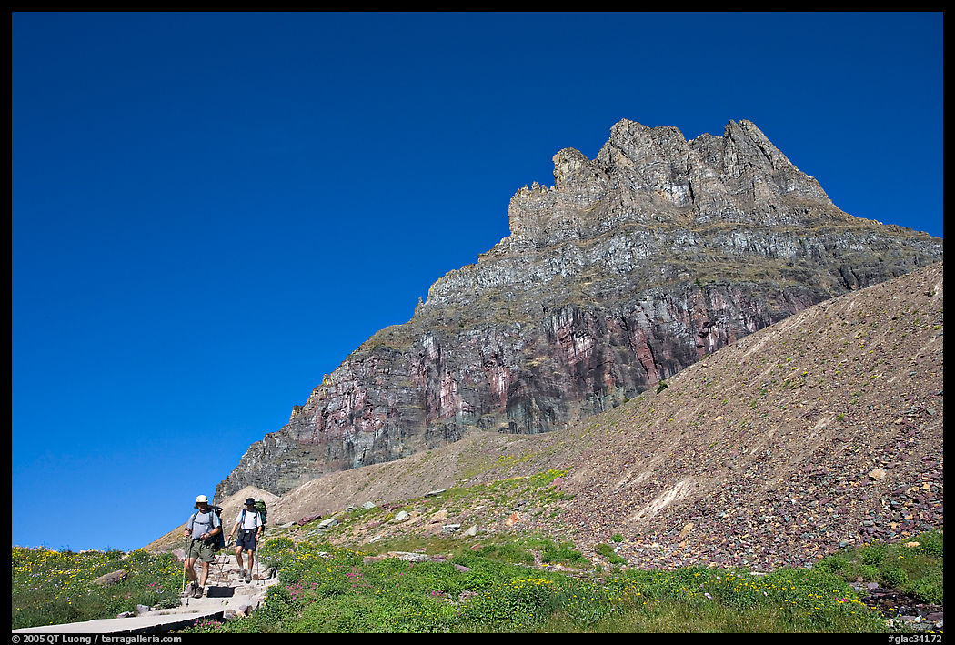 Two backpackers descending on trail near Logan Pass. Glacier National Park, Montana, USA.
