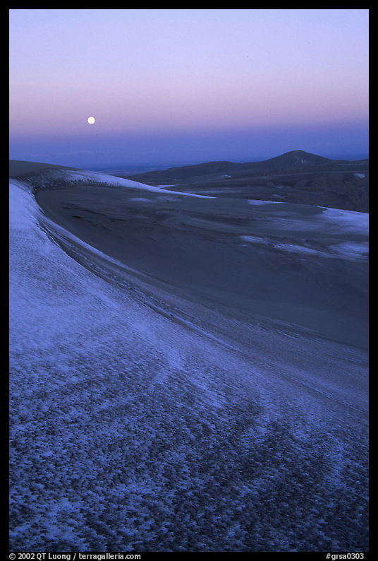 Dunes at dawn with snow and moon. Great Sand Dunes National Park, Colorado, USA.