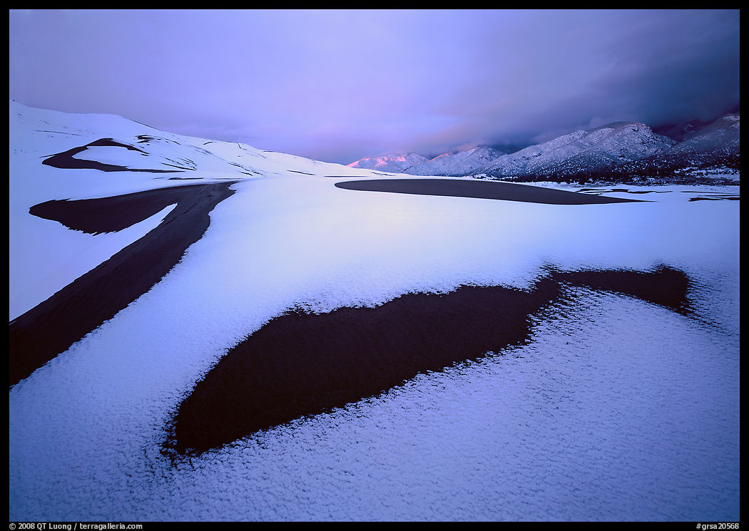Patch of sand in snow-covered dunes. Great Sand Dunes National Park, Colorado, USA.