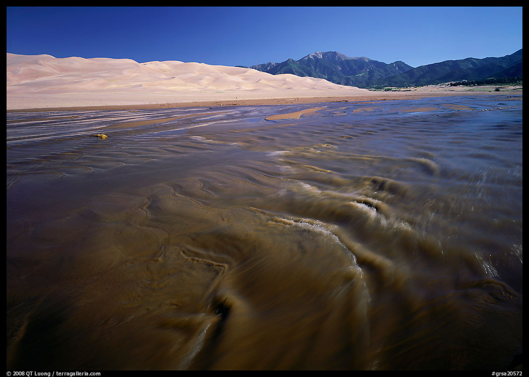 Mendonca creek with shifting sands, dunes and Sangre de Christo mountains. Great Sand Dunes National Park, Colorado, USA.
