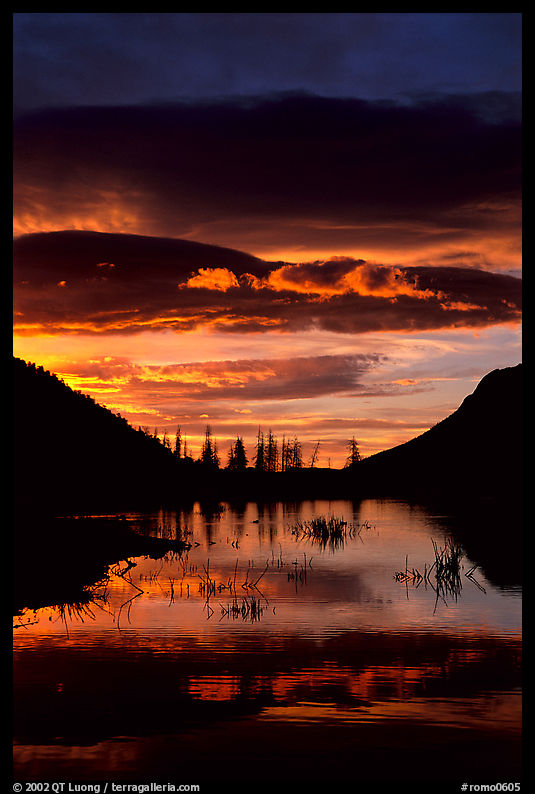 Sunrise with colorful clouds reflected on a pond in Horseshoe park. Rocky Mountain National Park, Colorado, USA.