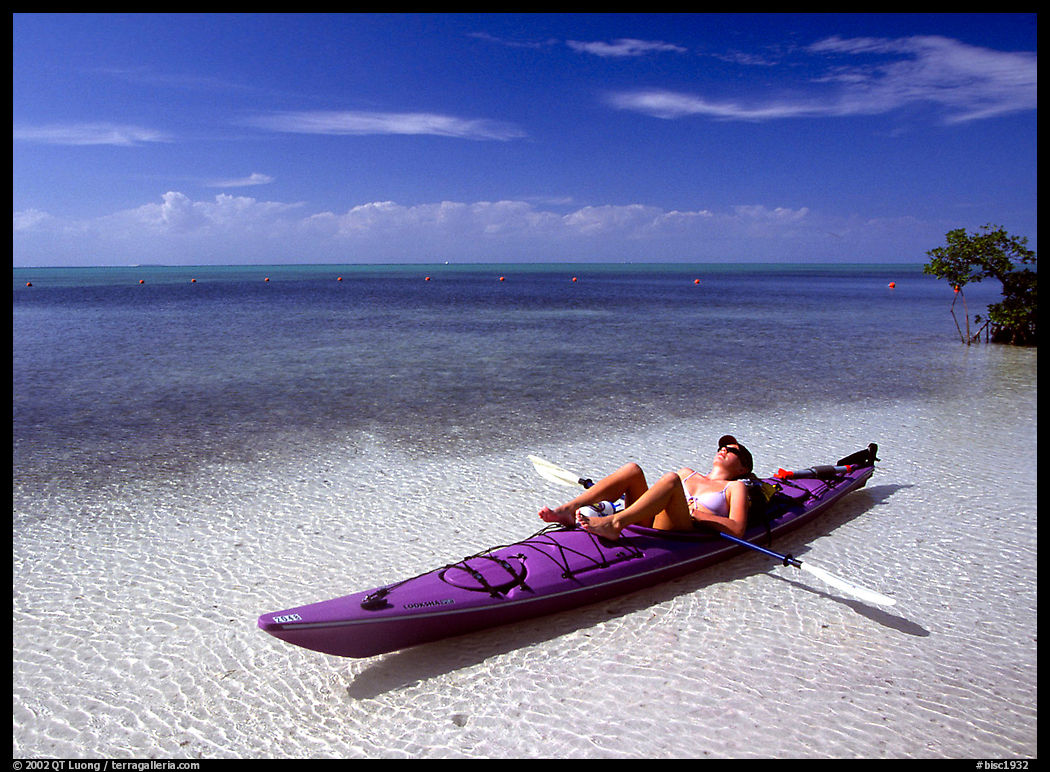Woman reclining in kayak on shallow waters,  Elliott Key. Biscayne National Park, Florida, USA.