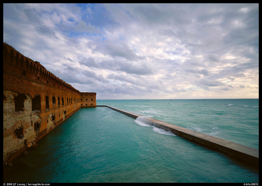 Fort Jefferson brick rampart and moat with wave over seawall, cloudy weather. Dry Tortugas  National Park, Florida, USA.