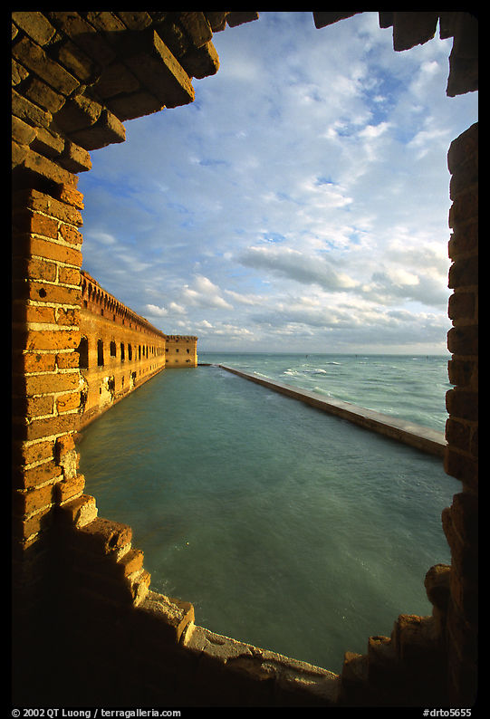 Fort Jefferson seawall and moat, framed by a crumpling embrasures, late afternoon. Dry Tortugas  National Park, Florida, USA.