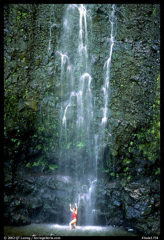 Visitor refreshes herself at the base of Waimoku Falls. Haleakala National Park, Hawaii, USA.