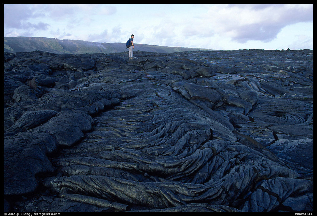 Hiker on hardened lava flow at the end of Chain of Craters road. Hawaii Volcanoes National Park, Hawaii, USA.