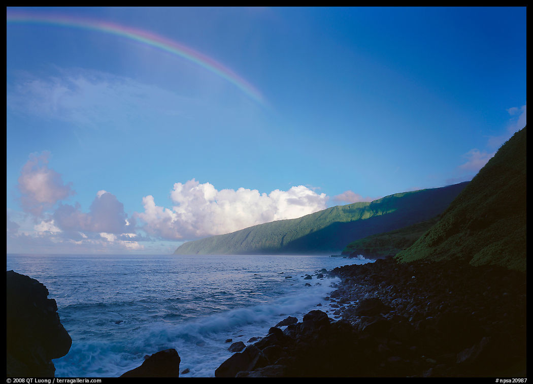 Rainbow and Mataalaosagamai sea cliffs in the distance, Tau Island. National Park of American Samoa