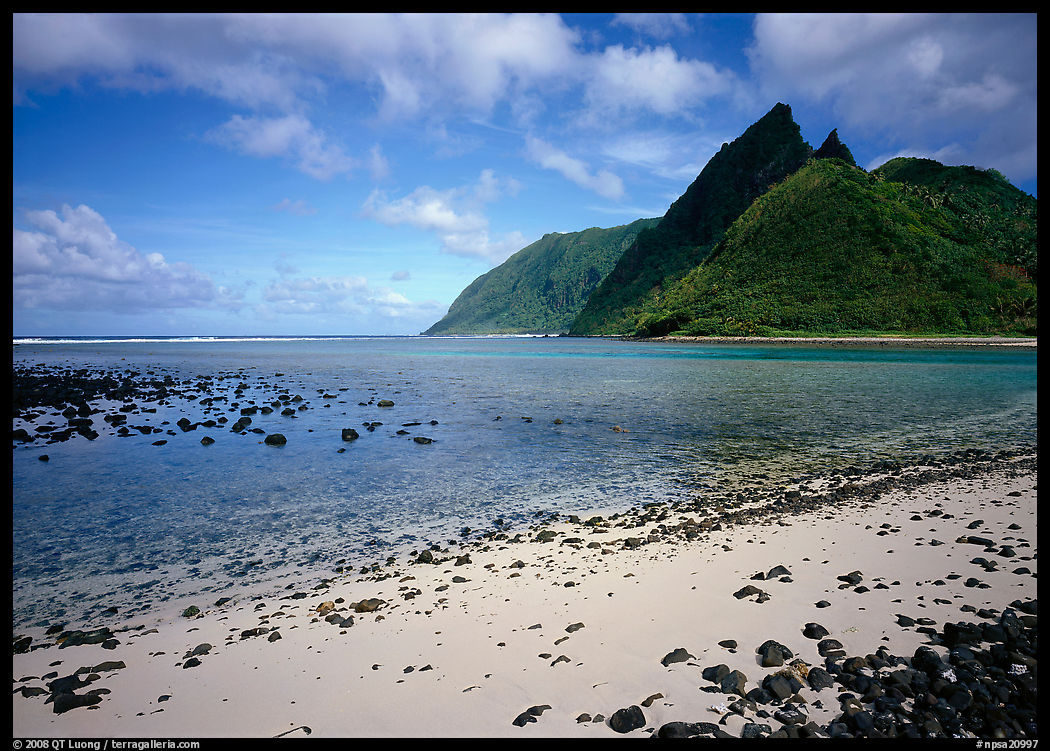 Tropical beach with sand and pebbles, and pointed peaks of Ofu Island. National Park of American Samoa