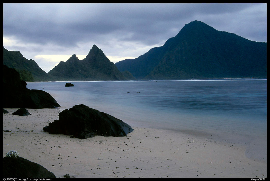 Balsalt boulders on South Beach, Sunuitao Peak and Piumafua mountain on Olosega Island in the background, Ofu Island. National Park of American Samoa