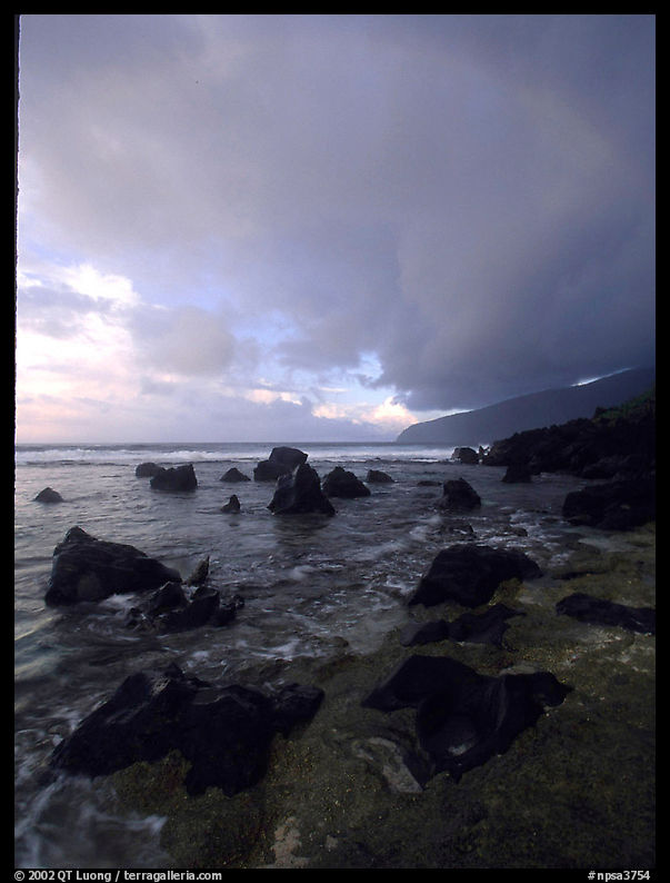 Boulders and coastline at sunrise with rainbow, Siu Point, Tau Island. National Park of American Samoa