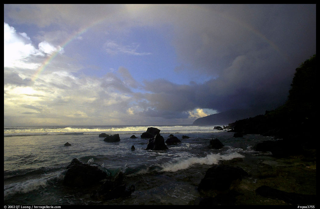 Boulders and coastline at sunrise with rainbow, Siu Point, Tau Island. National Park of American Samoa