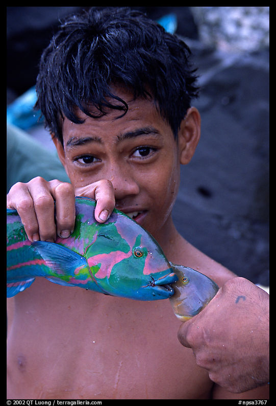 Samoan boy with freshly catched tropical fish, Tau Island. National Park of American Samoa