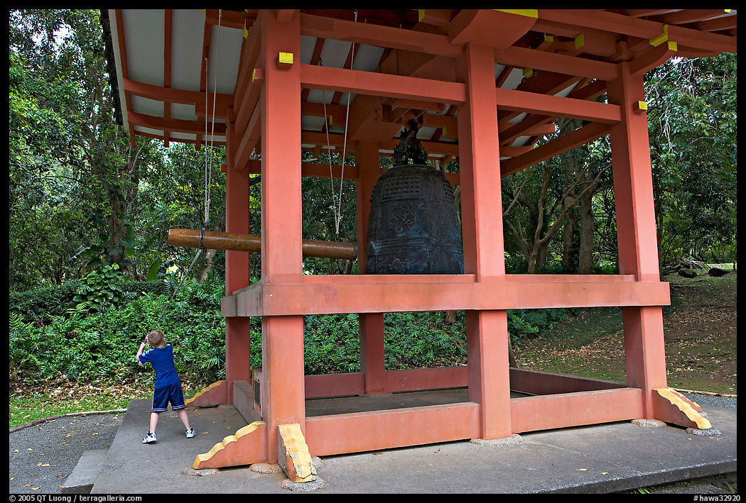 Boy ringing the buddhist bell, Byodo-In temple. Oahu island, Hawaii, USA