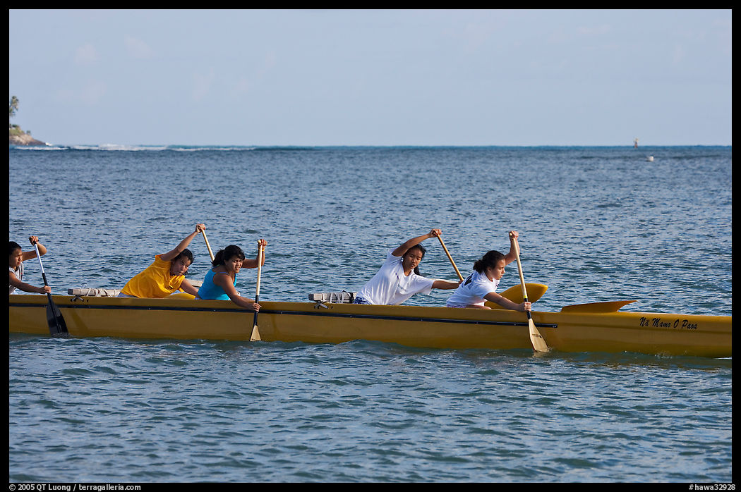 Young women padding a hawaiian outrigger canoe, Maunalua Bay, late afternoon. Oahu island, Hawaii, USA