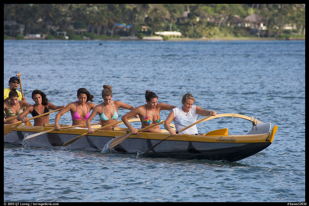 Outrigger canoe paddled by women in bikini, Maunalua Bay, late afternoon. Oahu island, Hawaii, USA