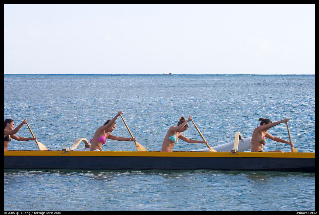 Side view of women in bikini paddling a outrigger canoe, Maunalua Bay, late afternoon. Oahu island, Hawaii, USA