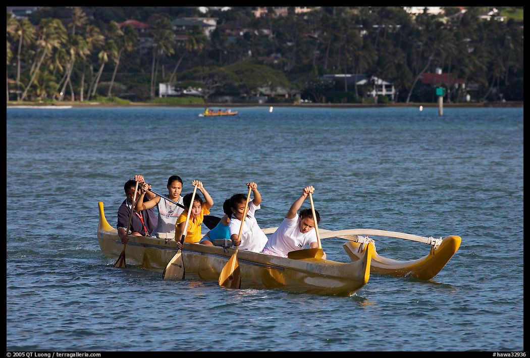 Girls paddling an outrigger canoe, Maunalua Bay, late afternoon. Oahu island, Hawaii, USA