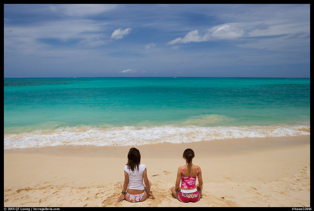 Young women facing the Ocean in a meditative pose on Waimanalo Beach. Oahu island, Hawaii, USA