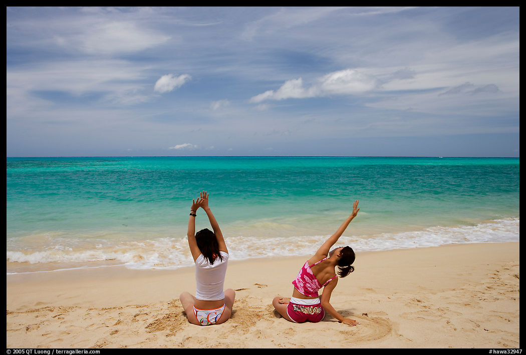 Young women stretching on Waimanalo Beach. Oahu island, Hawaii, USA