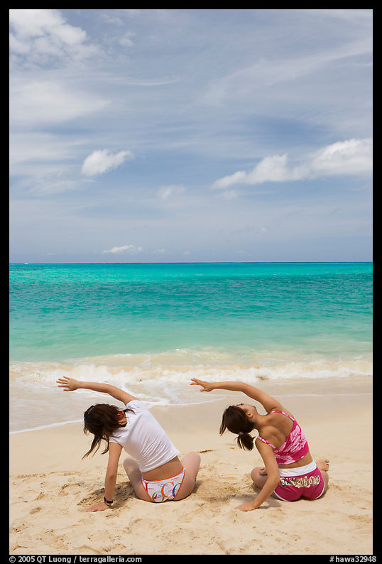 Young women doing gymnastics on Waimanalo Beach. Oahu island, Hawaii, USA