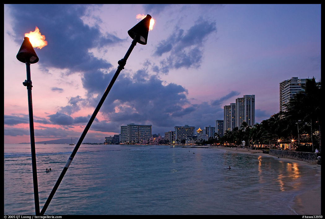 Bare flame torches and skyline at sunset. Waikiki, Honolulu, Oahu island, Hawaii, USA