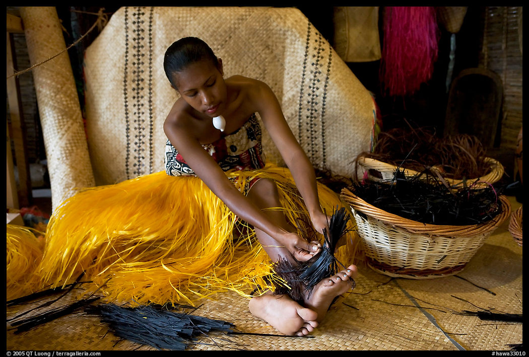 Fiji woman tying together leaves with her feet. Polynesian Cultural Center, Oahu island, Hawaii, USA