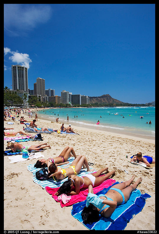 Young women on Waikiki Beach with skyline in the background. Waikiki, Honolulu, Oahu island, Hawaii, USA