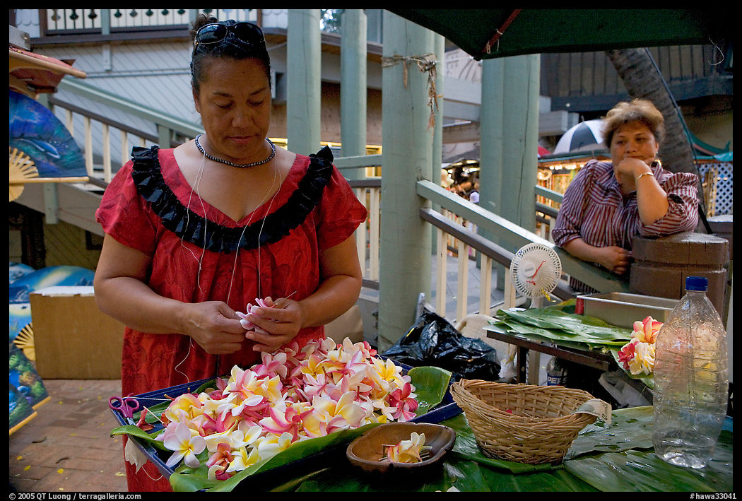 Woman preparing a fresh flower lei, with another woman looking, International Marketplace. Waikiki, Honolulu, Oahu island, Hawaii, USA