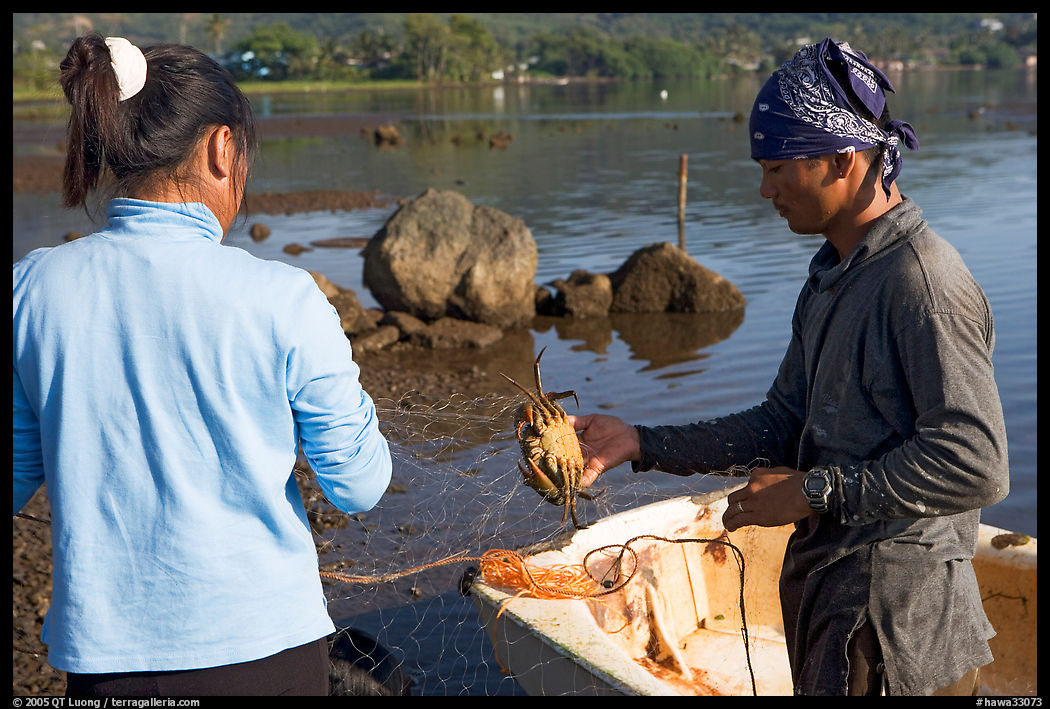 Fisherman giving a freshly caught crab to his wife, Kaneohe Bay, morning. Oahu island, Hawaii, USA