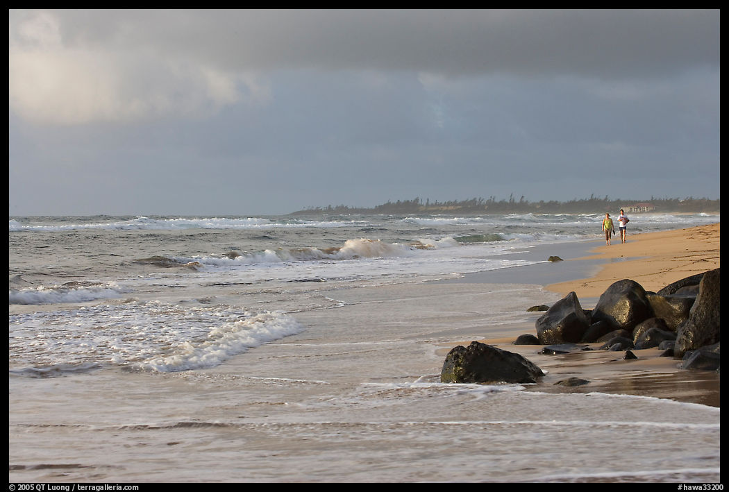 Couple strolling on the beach, Lydgate Park, early morning. Kauai island, Hawaii, USA
