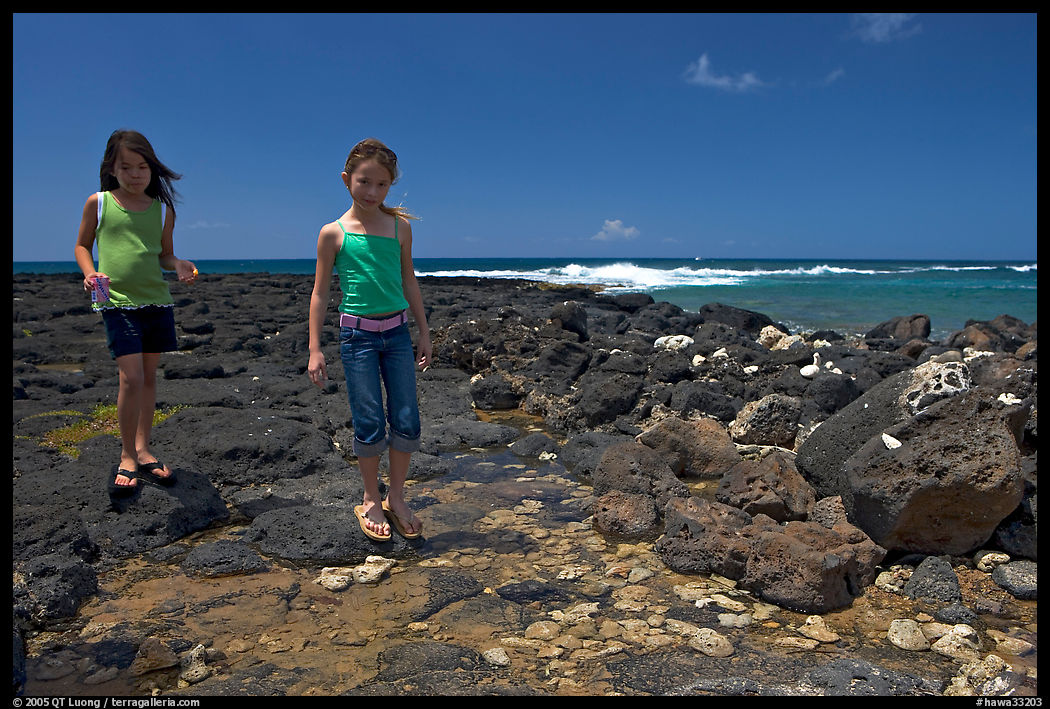 Girls playing in tidepool, Kukuila. Kauai island, Hawaii, USA
